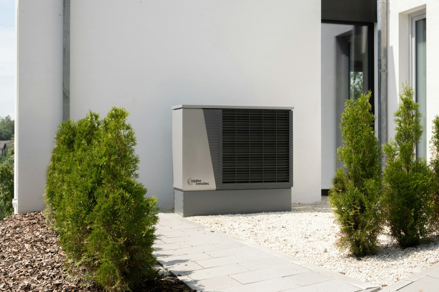 Moderne Wärmepumpe an der Außenwand eines Wohnhauses
