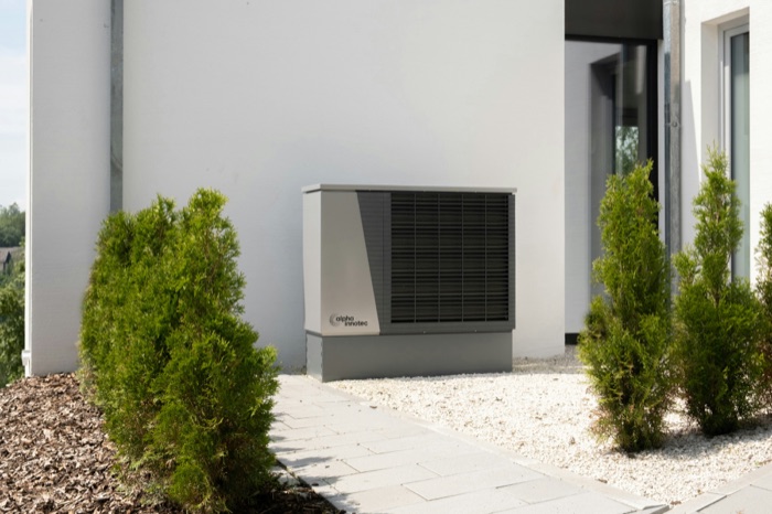 Wärmepumpe vor einem Wohnhaus – Symbolbild für die KfW-Förderung 2026